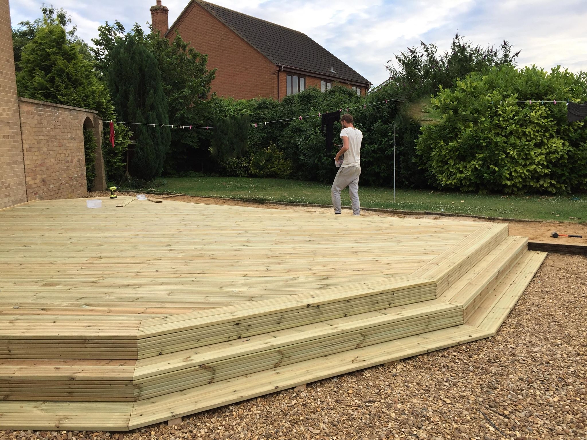 A large stepped timber deck being built on a gravel base